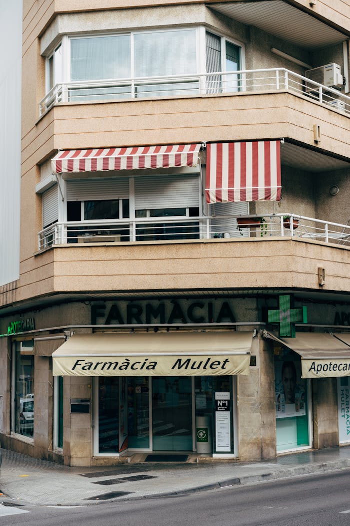 A classic Spanish pharmacy with striped awnings in Palma, showcasing Mediterranean architecture.